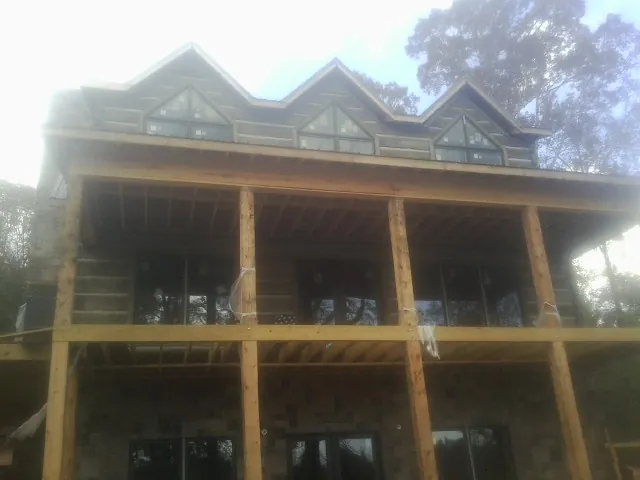 Dormers and porch framing on a large log home under construction — Roof Coating work by our crew in Stevenson