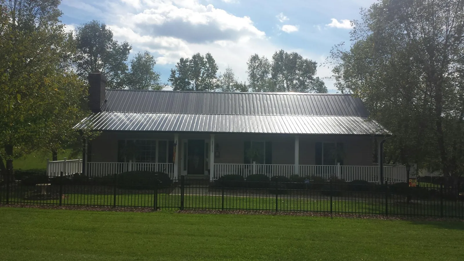 Gray metal roof on a brick ranch with a full width front porch — Gutter Guard Installation work by our crew in Stevenson
